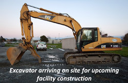 Excavator arriving on site for upcoming facility construction