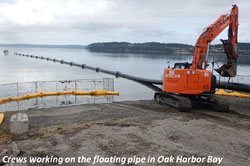 Crews working on ght floating pipe in Oak Harbor Bay